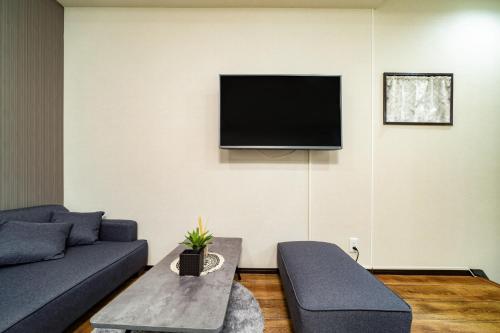 a living room with a couch and a tv on the wall at 72, Nakanobu A, Entire house for rent, 中延A in Tokyo