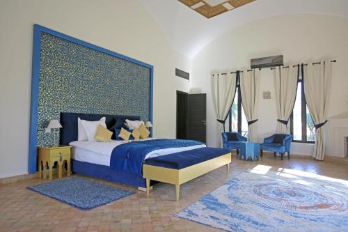 1 dormitorio con 1 cama azul y sillas azules en Domaine DAR JMEL & Dar Abi Samama, en Marrakech
