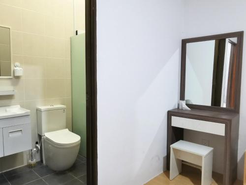 a bathroom with a toilet and a mirror at pen kyu house1 in Kota Samarahan