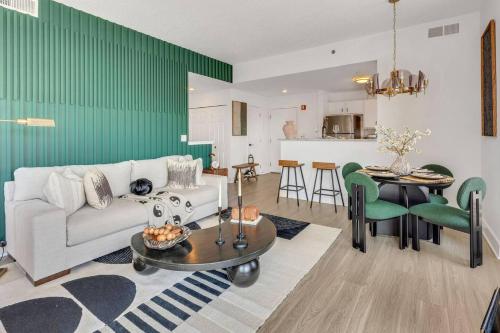 a living room with a white couch and a green wall at Penthouse Perfection With Unmatched Skyline Views in Stamford