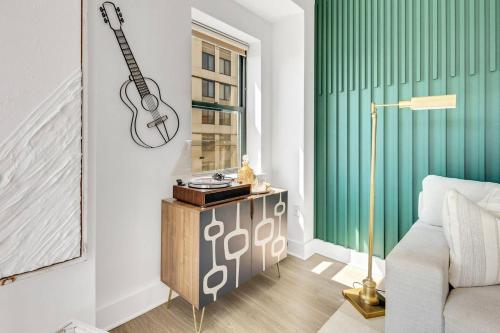 a living room with a guitar on the wall at Penthouse Perfection With Unmatched Skyline Views in Stamford