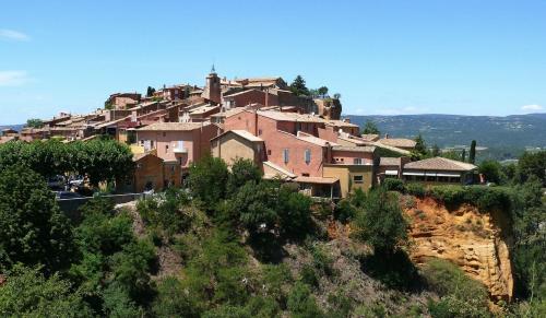 un village au sommet d'une colline avec des maisons dans l'établissement Appartement centre village, à Roussillon