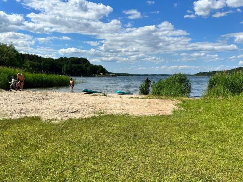 a person standing on a beach next to a body of water at Tiny House Carlos - zauberhaftes Camping-Pod in Stuer
