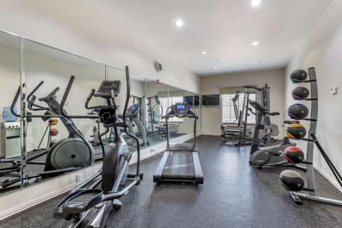 a gym with several tread machines and a mirror at Best Western Sugarland Inn in Sugar Land