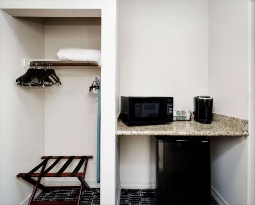 a room with a small kitchen with a microwave and a counter at Best Western Sugarland Inn in Sugar Land