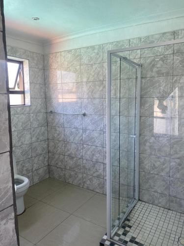 a bathroom with a shower and a toilet at 606 Guesthouse in Bushbuckridge