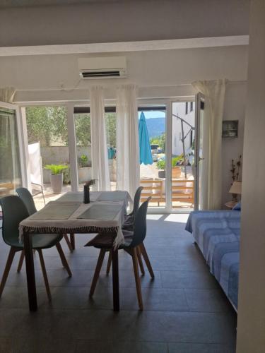 a living room with a table and chairs and a bed at Obala 111 in Poljica
