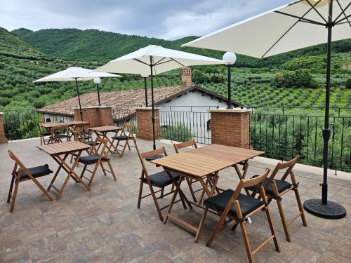een groep tafels en stoelen met parasols op een patio bij CASALE DEI PRIORI in Rocca Massima