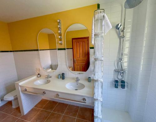a bathroom with two sinks and a mirror at Roca de Guía Somiedo in Pola de Somiedo