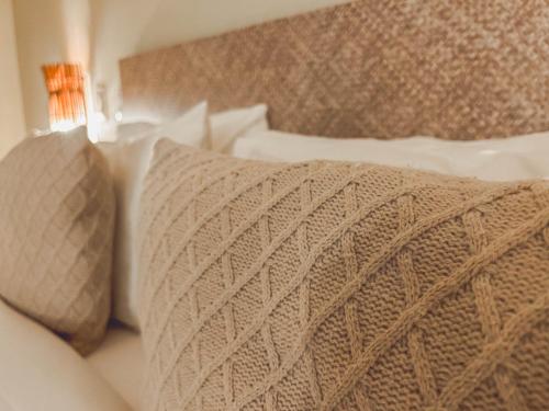 a bed with a blanket and pillows on it at Kastel Jampa Hotel in João Pessoa