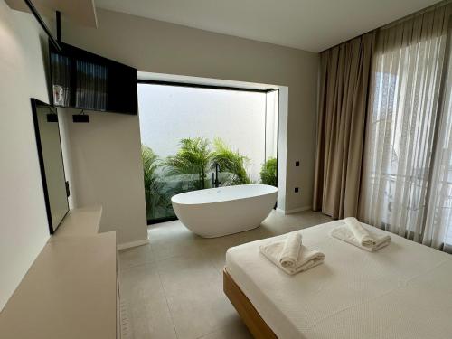 a bathroom with a bath tub and a large window at Ashta Suites - Nora Suite in Fethiye