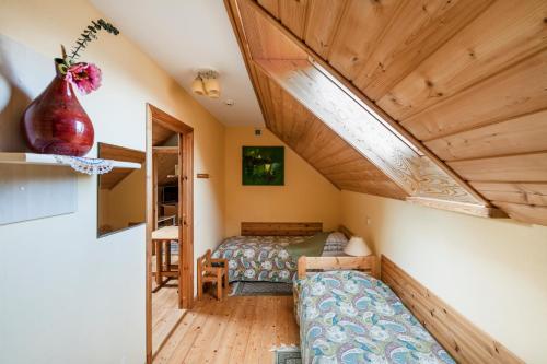 a room with two beds in a room with wooden ceilings at Provincija in Palanga