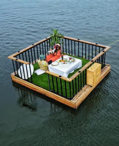 a wooden pier with a table on the water at Divine Resort & Spa in Kampala
