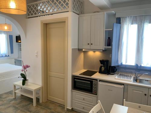 a kitchen with white cabinets and a sink at Dolphin Studios in Astypalaia Town