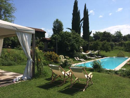 a yard with two chairs and a swimming pool at Maso Di Villa Relais di Campagna in Susegana