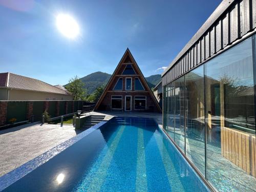 a house with a swimming pool in front of a building at Qafqaz Suite Paradise Chalet & SPA in Gabala