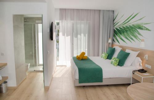 a bedroom with a bed with a teddy bear on it at BQ Paguera Boutique Hotel - Adults Only in Paguera