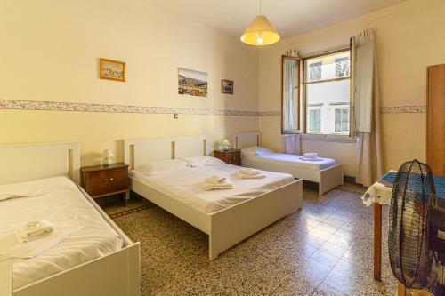 a bedroom with two beds and a window at Soggiorno Primavera in Florence