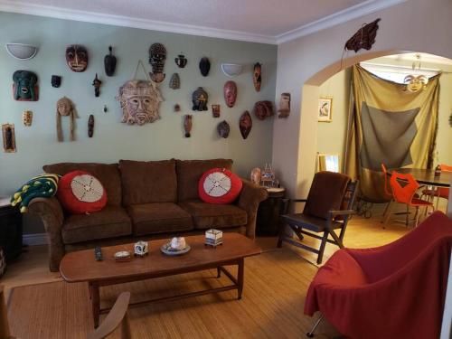 a living room with a couch and clocks on the wall at Mission Historical Home in Calgary