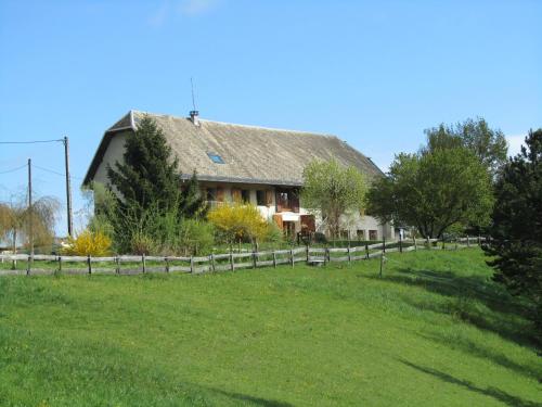 une maison dans un champ avec une clôture dans l'établissement La chambre du Tilleul de la Tarte Qui Flette, à Saint-Sulpice