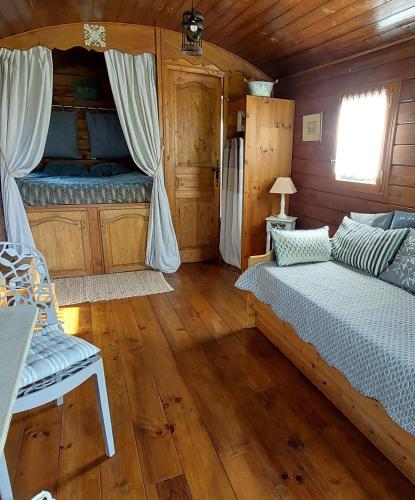 - une chambre avec 2 lits dans une cabane en bois dans l'établissement Les roulottes de la Brauderie, à Les Varennes