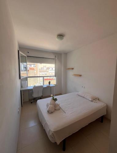 a bedroom with a bed and a window and a desk at apartamento 4 in Benicarló