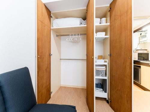 a small room with a closet and a blue chair at Nakameguro & Ikejiri-Ohashi 10min walk, Queen Bed, Switch, Free Wi-Fi, PocketWi-Fi in Tokyo