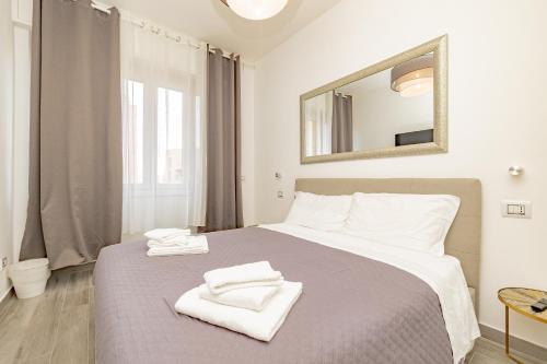 une chambre avec un grand lit avec des serviettes dessus dans l'établissement Cozy Room - 2, à Milan