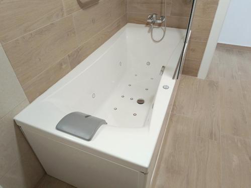 a white bath tub with a gray object on it at El Hostalito in Fuensanta