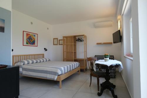 a bedroom with two beds and a table and a television at Villa Finocchito - The sound of silence in Ogliastro Cilento