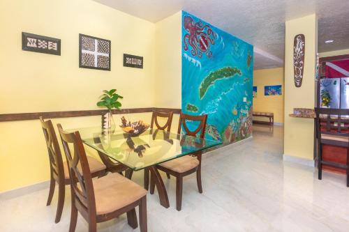 a dining room with a glass table and chairs at Del Playa #3 Condo in West End