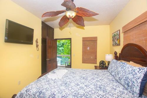 a bedroom with a bed with a ceiling fan at Del Playa #3 Condo in West End