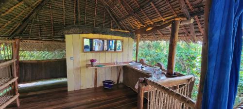 a bathroom in a hut with a sink in it at Chole Mjini Treehouses Lodge in Utende