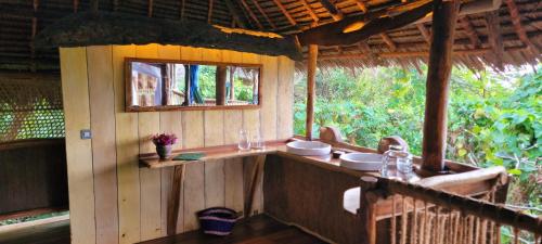a bathroom in a house with a sink and a window at Chole Mjini Treehouses Lodge in Utende
