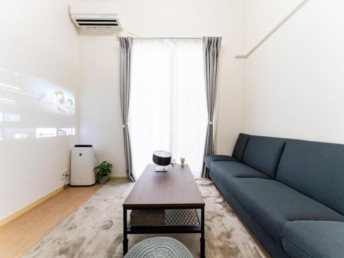 a living room with a blue couch and a coffee table at Nakameguro & Ikejiri-Ohashi 10min walk, Queen Bed, Switch, Free Wi-Fi, PocketWi-Fi in Tokyo