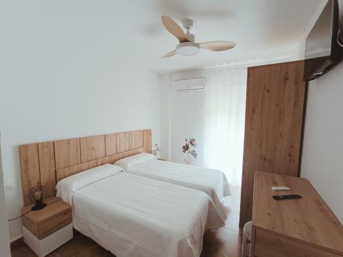 a bedroom with two beds and a ceiling fan at El Hostalito in Fuensanta