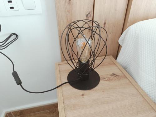 a black lamp sitting on a table next to a bed at El Hostalito in Fuensanta