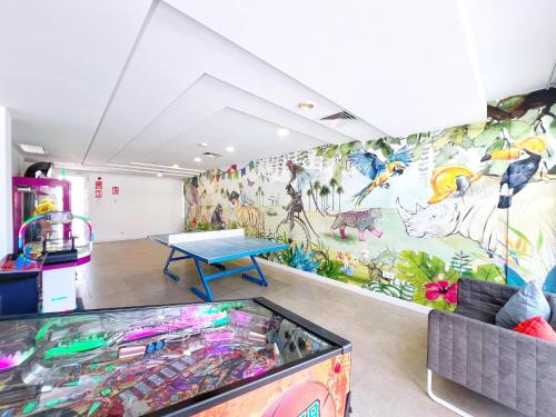 a room with a table and a mural at Ibersol Siurell in Sa Coma
