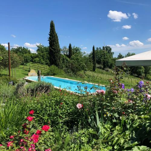 a swimming pool in a garden with flowers at Maso Di Villa Relais di Campagna in Susegana