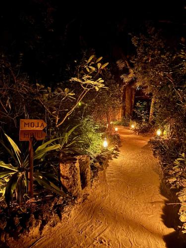 a dirt road with a no parking sign at night at Chole Mjini Treehouses Lodge in Utende