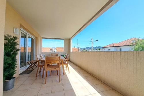 un patio avec une table et des chaises sur un balcon dans l'établissement 3BR in Cannes with Swimming Pool Terraces Parking & AC - BENAKEY, à Cannes