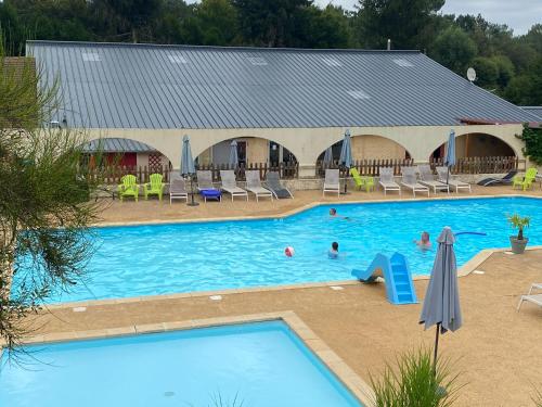 une grande piscine avec des gens dans l'eau dans l'établissement Locations au camping Les Pialades, à Nabirat