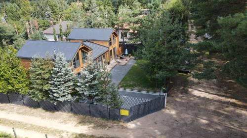 an overhead view of a house with a fence and trees at DOMKI Leśna Cisza jezioro Powidzkie dla 18 osób - 5D Apartments in Lipnica