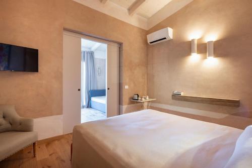 a bedroom with a bed and a tv and a couch at Guadalupe Tuscany Resort in Braccagni