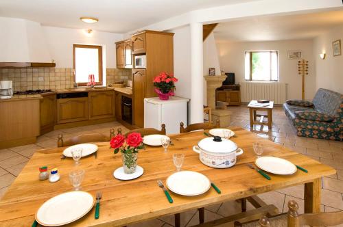 - une table en bois avec des assiettes dans la cuisine dans l'établissement Gîte Gîtes de France 4/6 personnes à Chasseradès, à Chasseradès