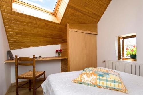 Un dormitorio con una cama y un escritorio y una ventana. en Gîte Gîtes de France 4/6 personnes à Chasseradès, en Chasseradès