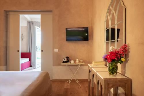 a bedroom with a bed and a vase of flowers on a table at Guadalupe Tuscany Resort in Braccagni