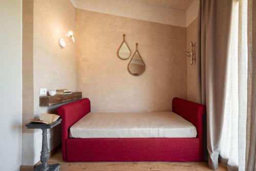 a red couch in a room with a window at Guadalupe Tuscany Resort in Braccagni