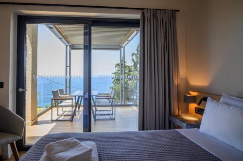 a bedroom with a bed and a view of the ocean at Mani Suites in Agios Nikolaos