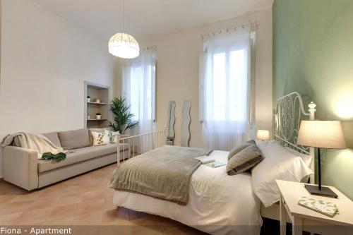 a bedroom with a bed and a couch at Mamo Florence - Fiesolana Apartments in Florence